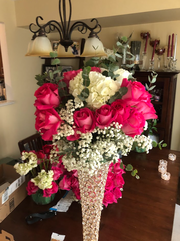 A vase filled with pink and white flowers sits on a table