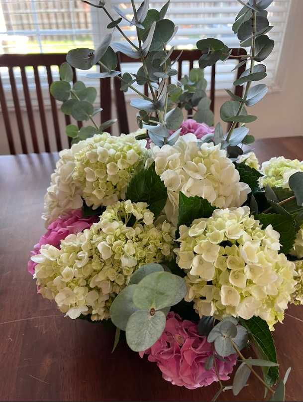 A bunch of flowers are sitting on a wooden table.