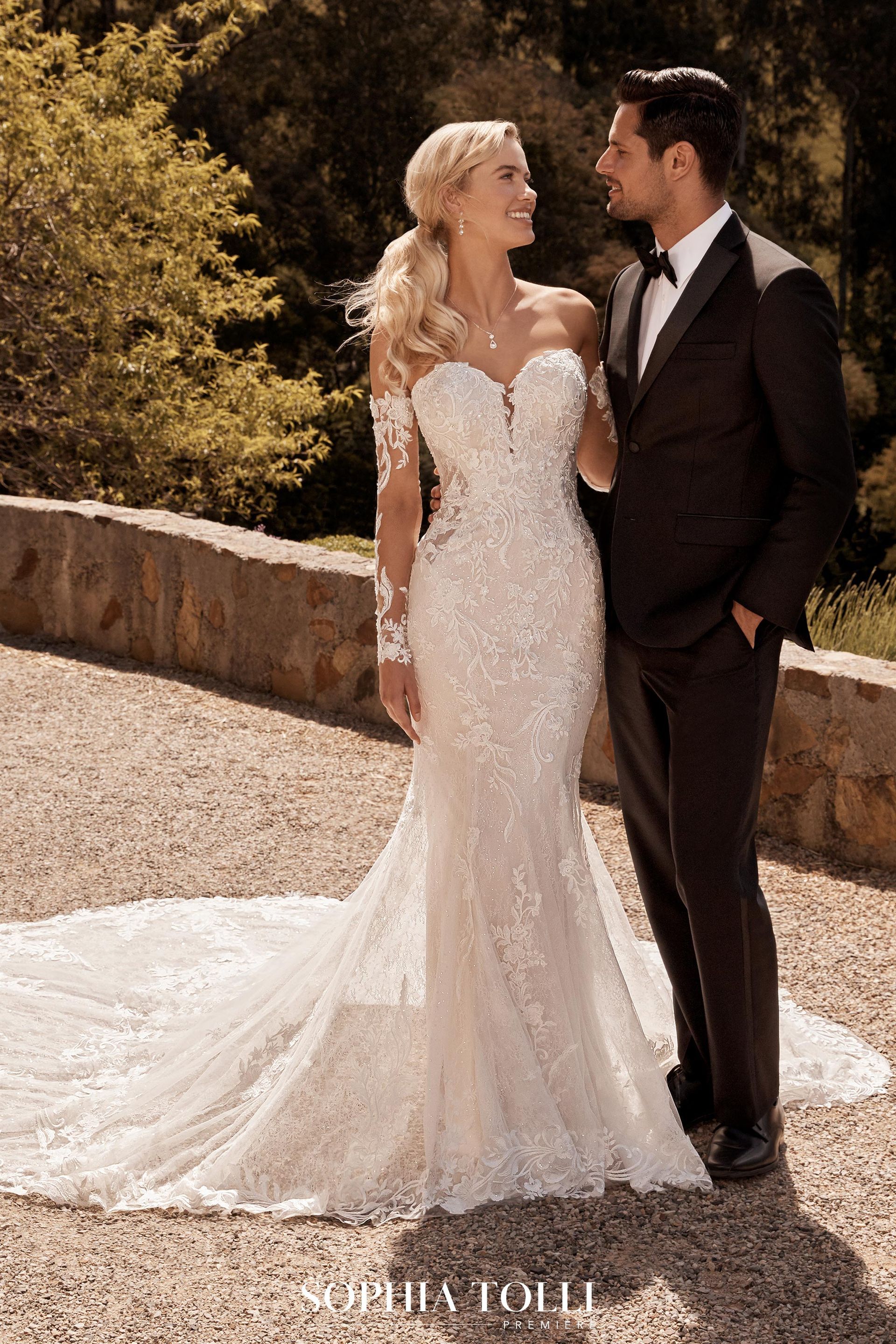 A bride and groom are standing next to each other in a wedding dress and tuxedo.