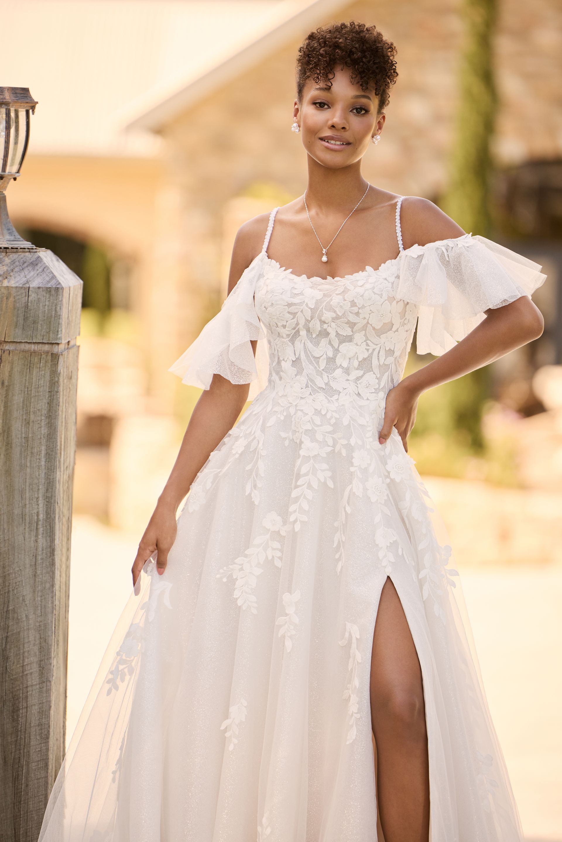 A woman is wearing a white wedding dress with a high slit.