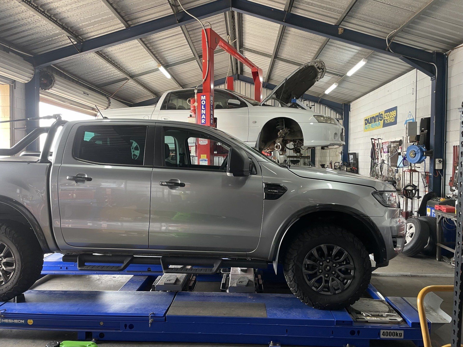 A Silver Pickup Truck on A Lift — Dunn's Auto Repair in Bundaberg East, QLD