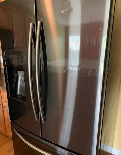 Black stainless steel refrigerator with double doors and a water dispenser.