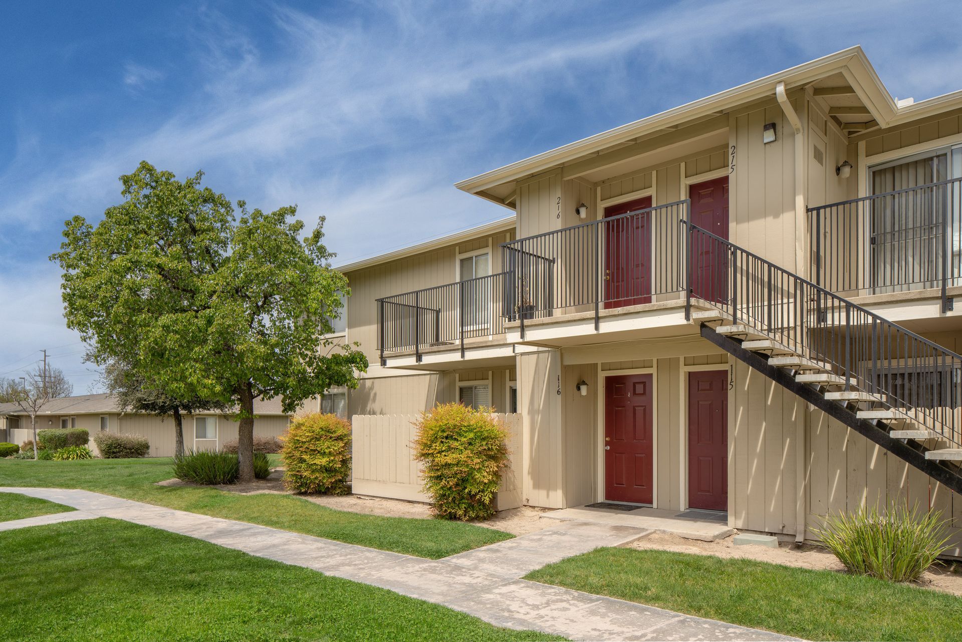 Round wooden coffee table with decor in a living room with a couch and window.