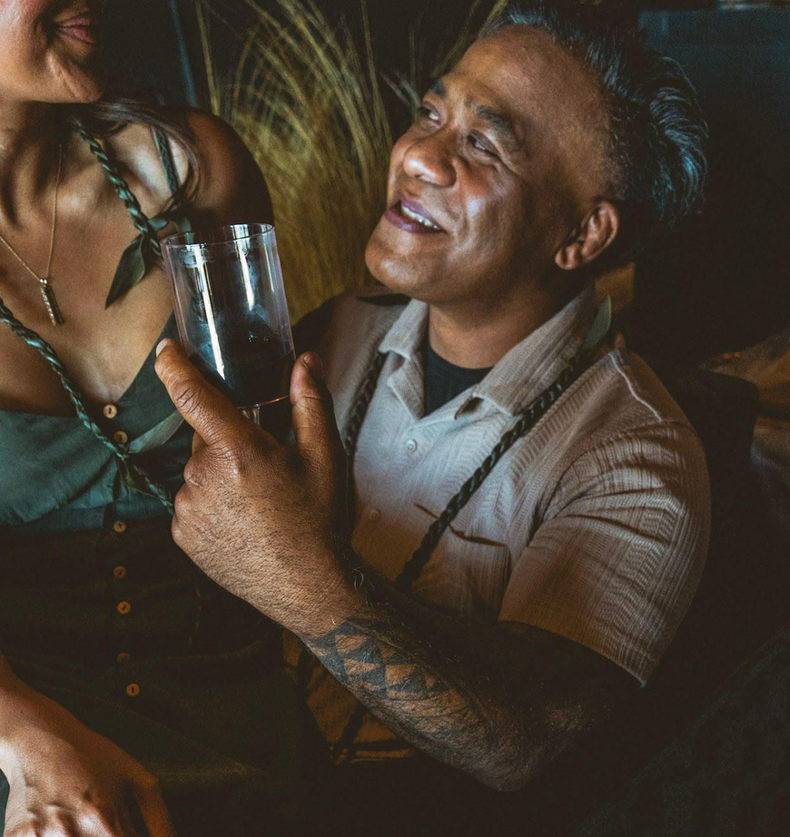 Red wine, grapes, cheese, and meats arranged on a wooden table for a tasting.
