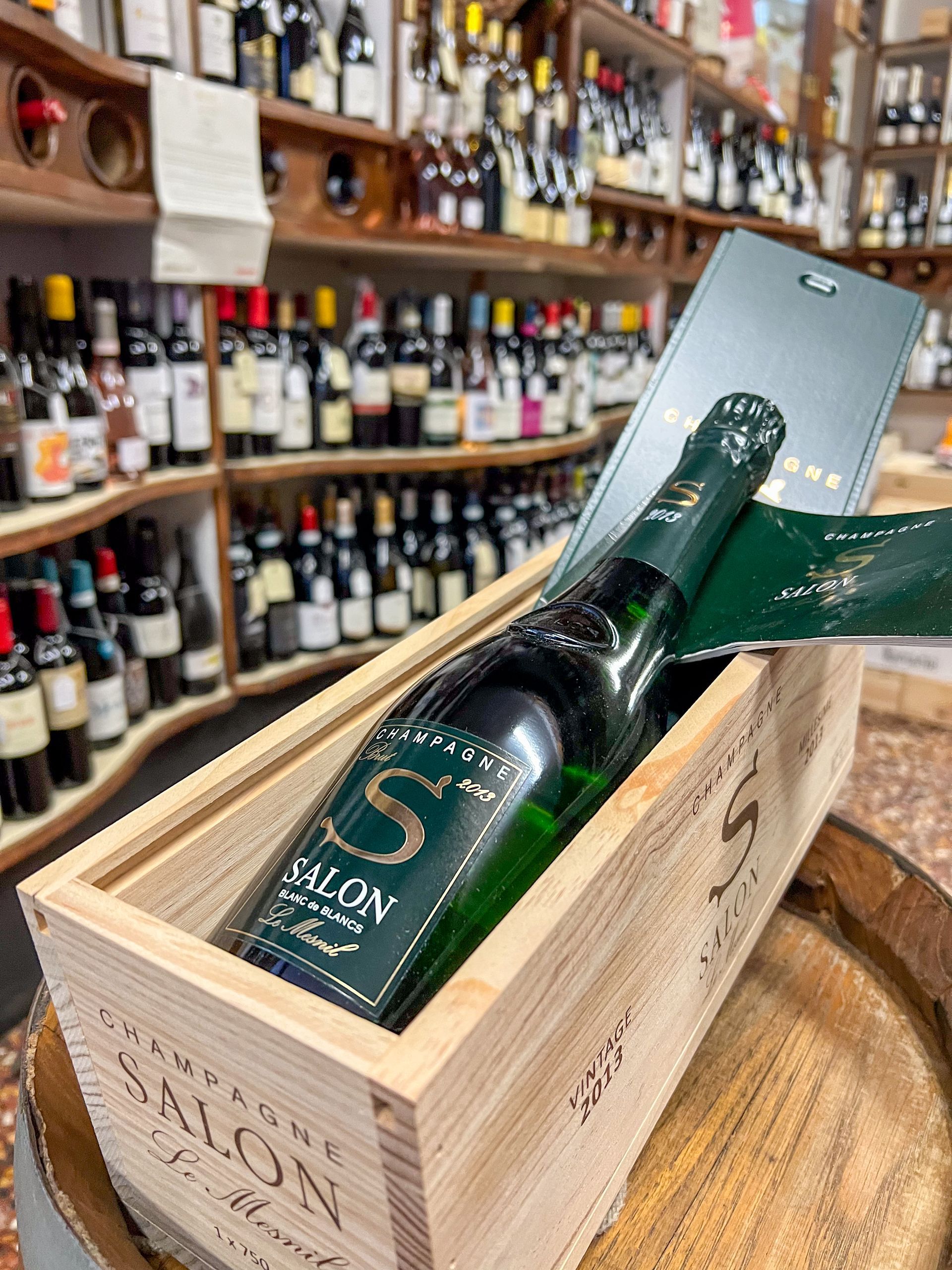 Bottiglia di champagne e sullo sfondo alcune bottiglie dell'enoteca