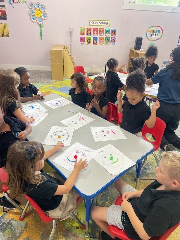 A group of children are playing on a merry go round at a playground.