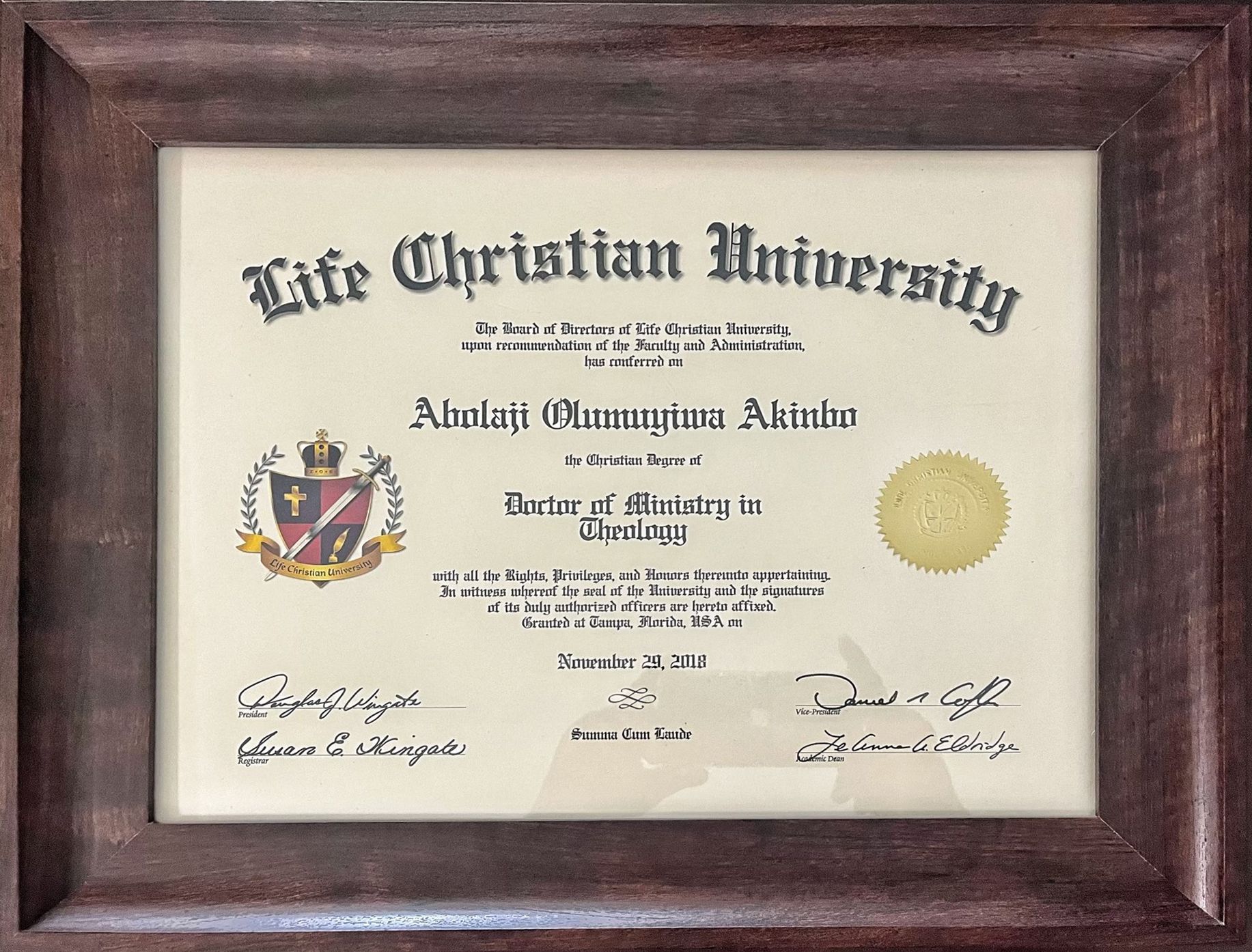 A life christian university diploma in a wooden frame