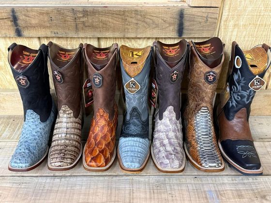 A room filled with lots of cowboy boots on display.