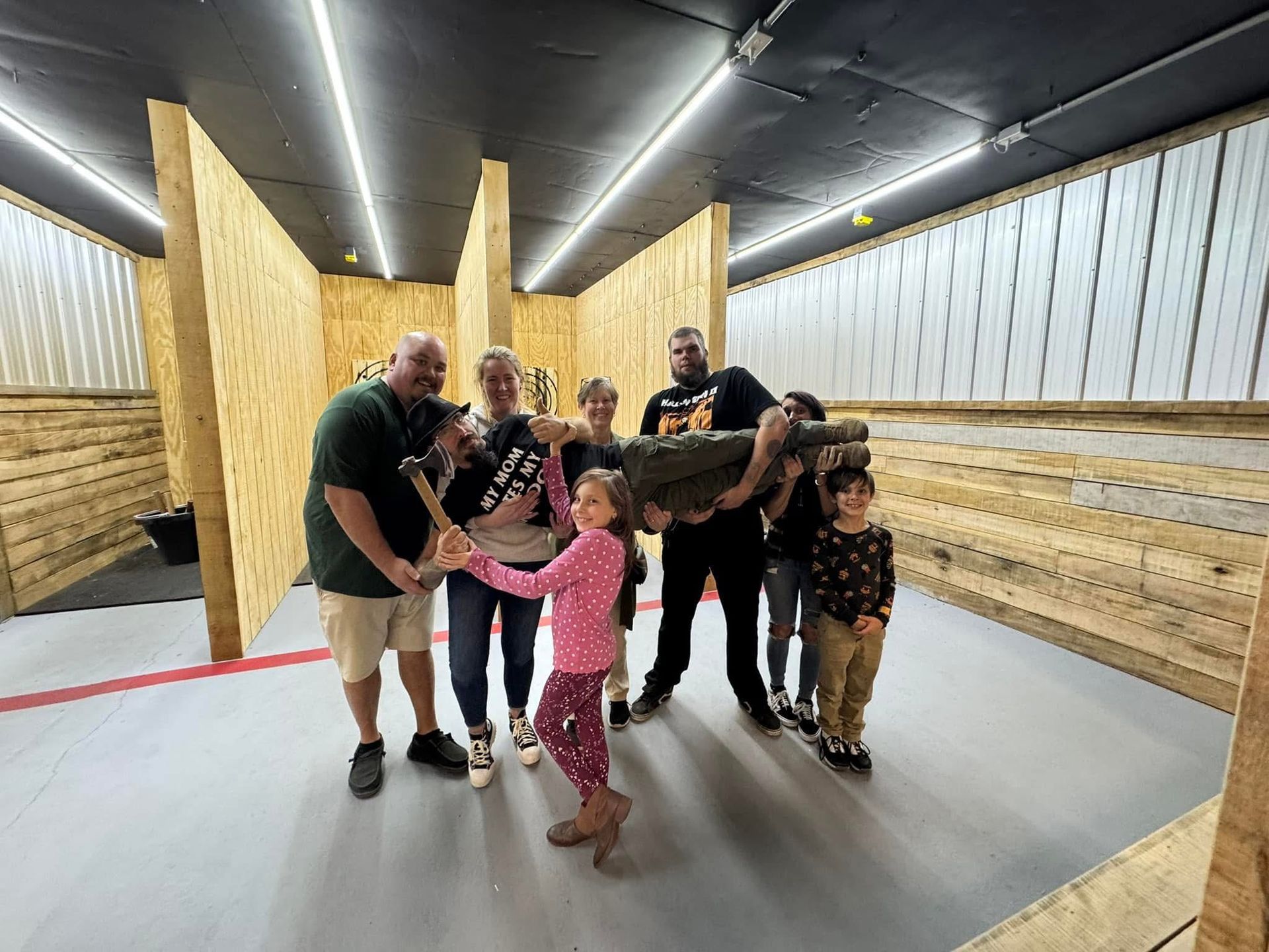 A group of people standing next to each other in a room holding axes.