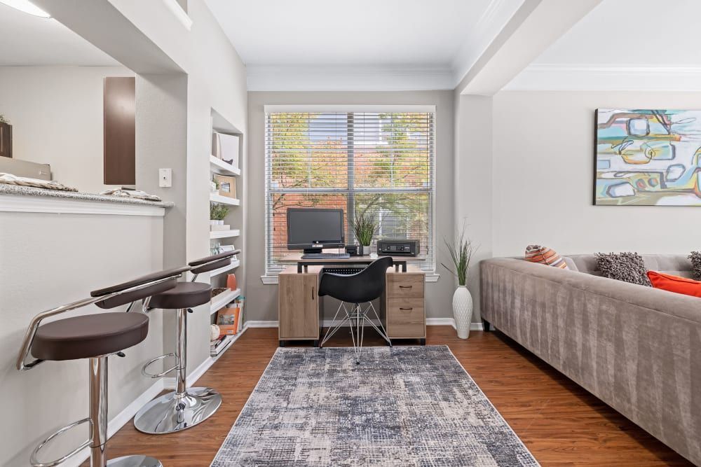 a living room with a couch and a desk with a computer on it at Marquis on Gaston in Dallas, TX.