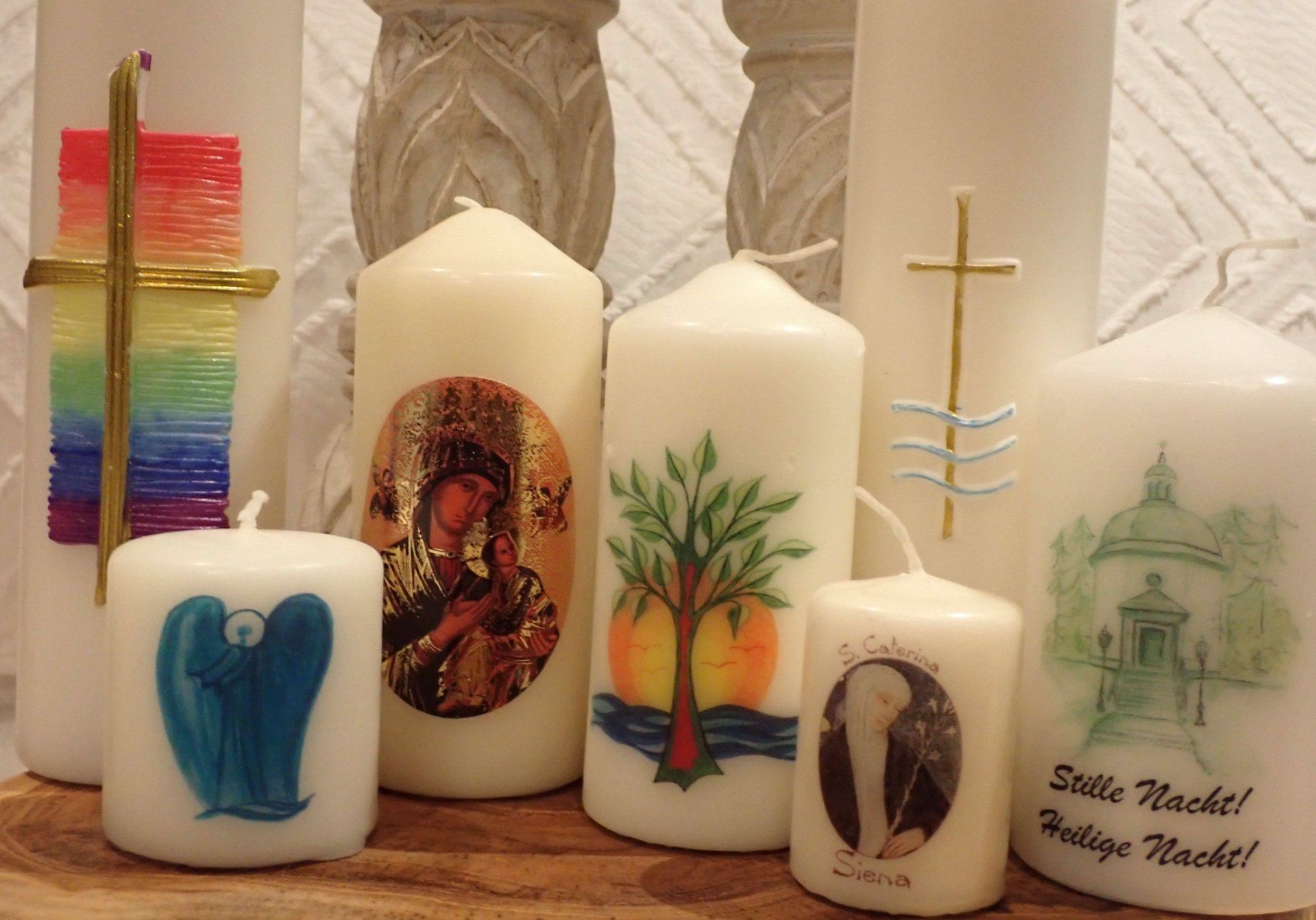 A group of white candles with different designs on them