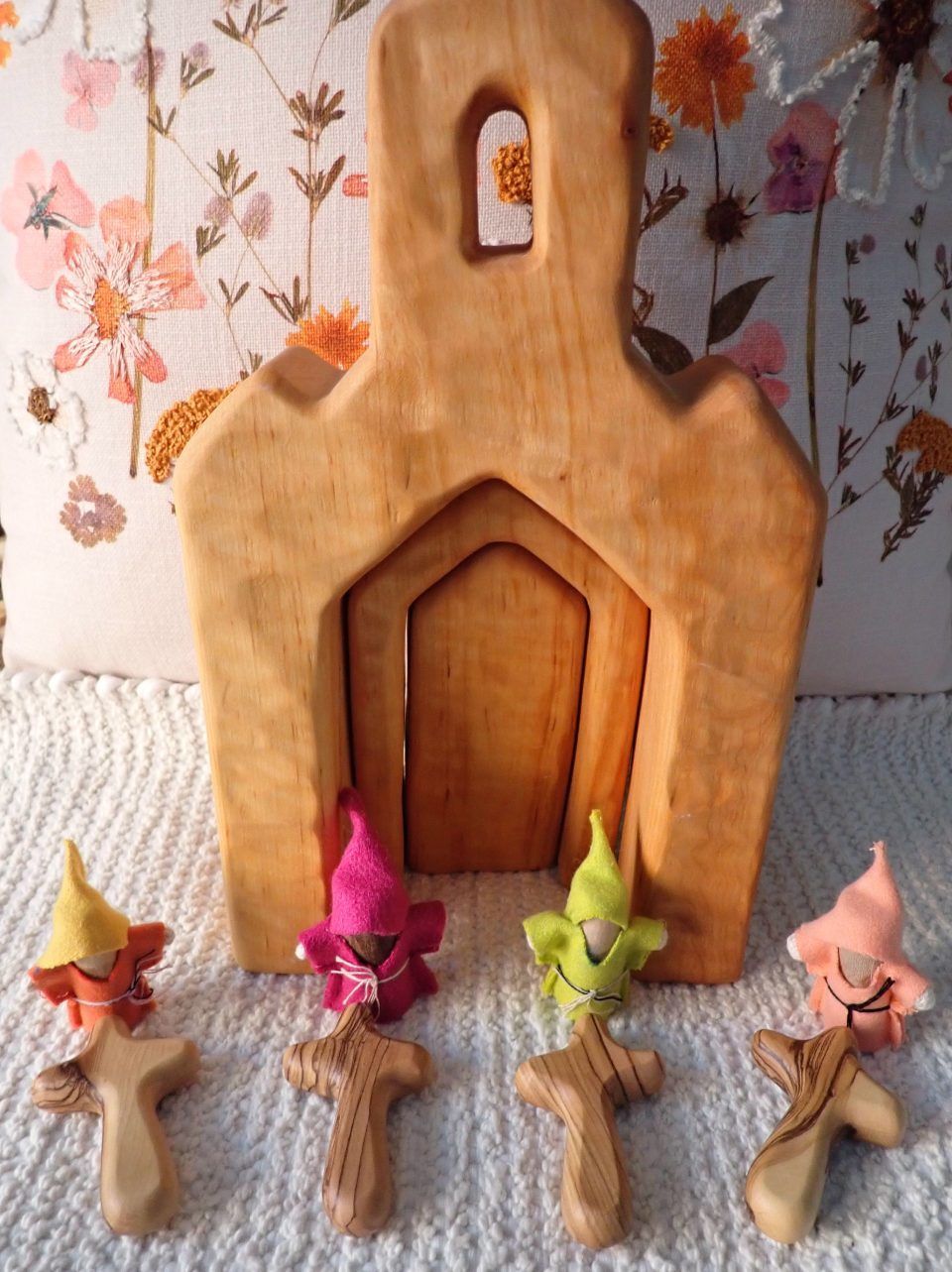 A wooden church with gnomes and crosses in front of it