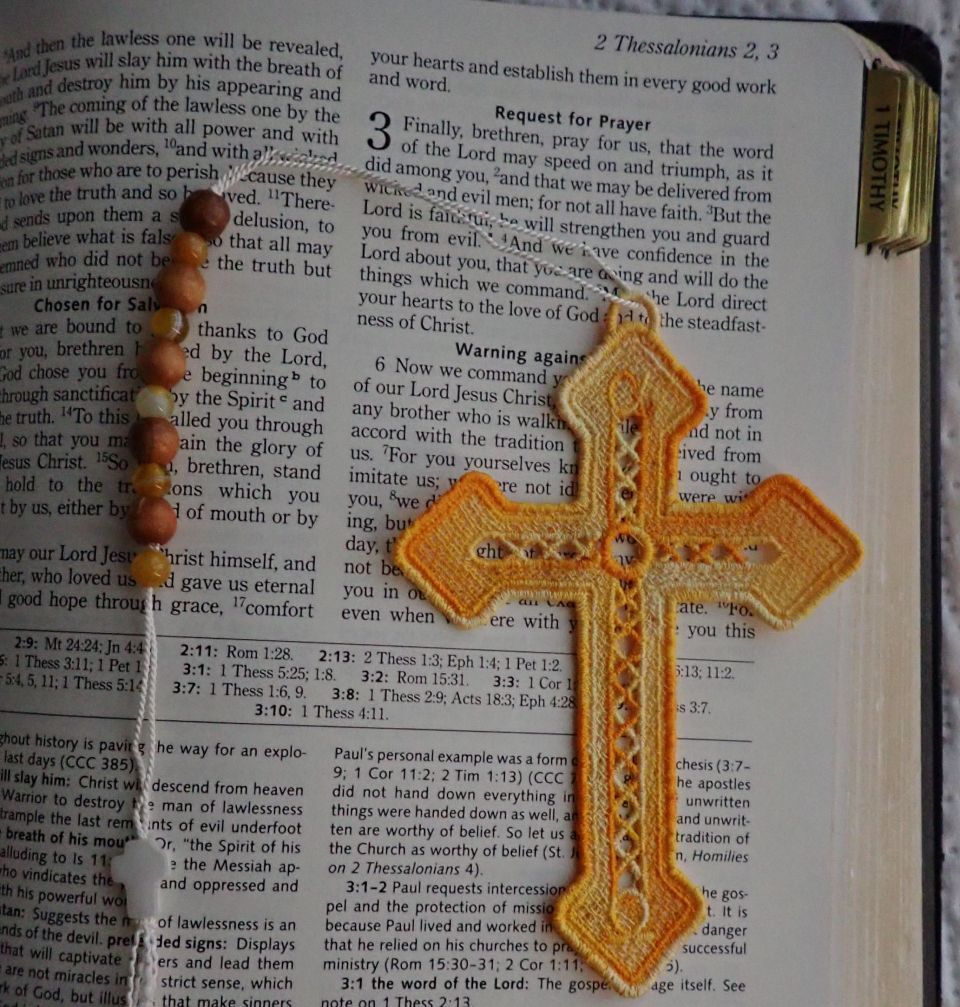 A cross is sitting on top of a bible page