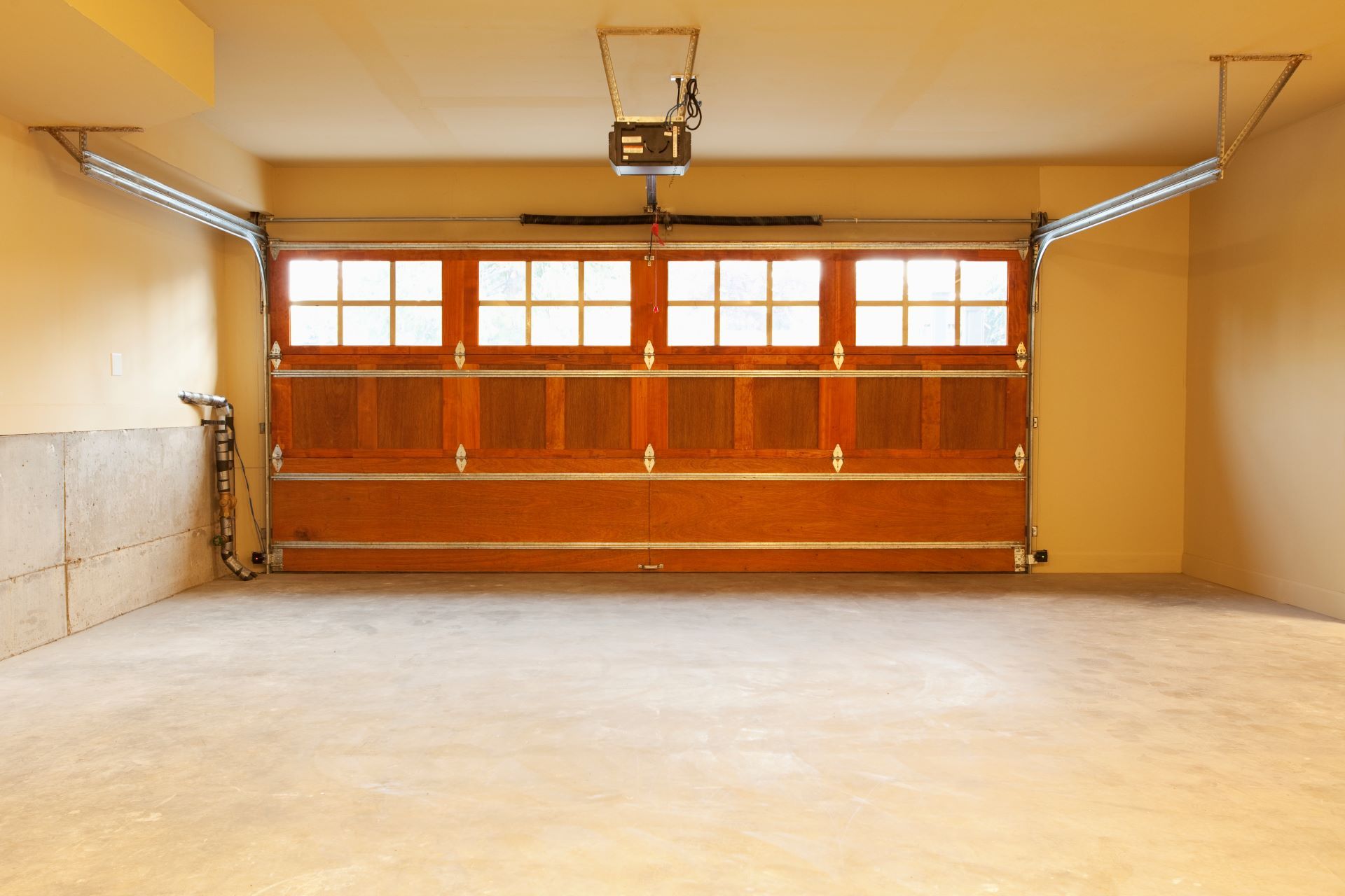 An empty garage with a wooden garage door and a lift.
