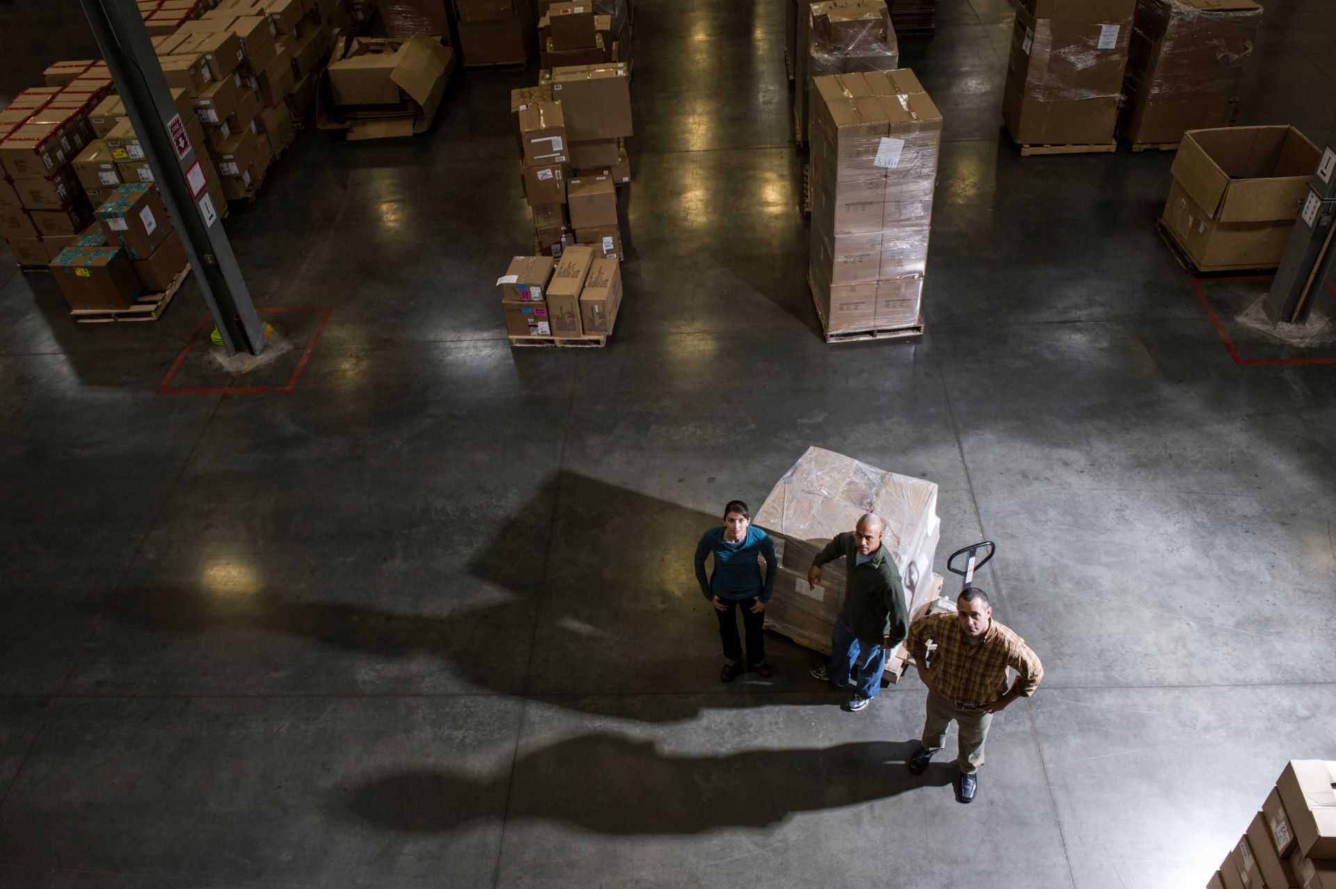 A group of people are standing in a large warehouse.