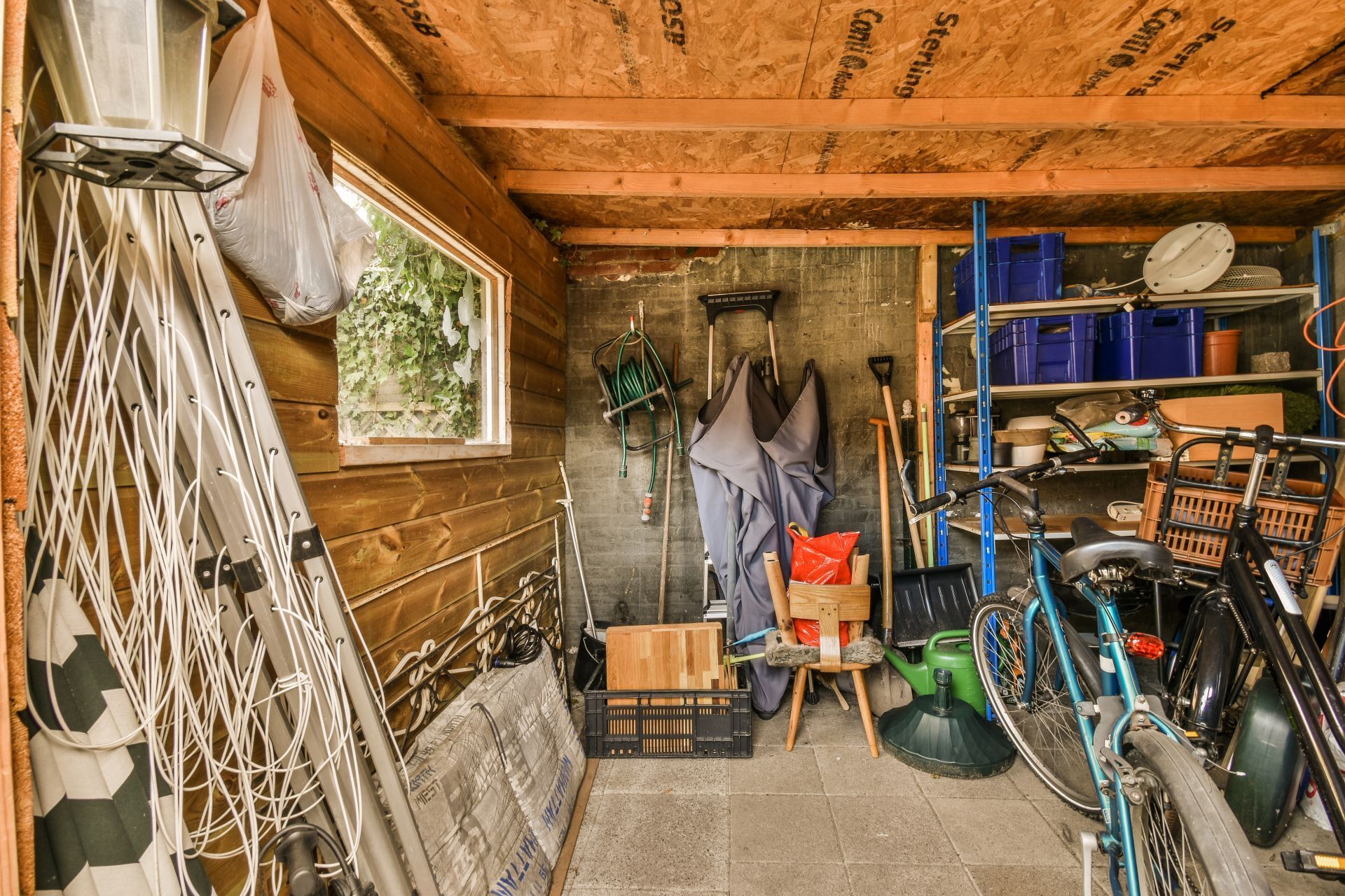 A garage filled with lots of bicycles and other items.