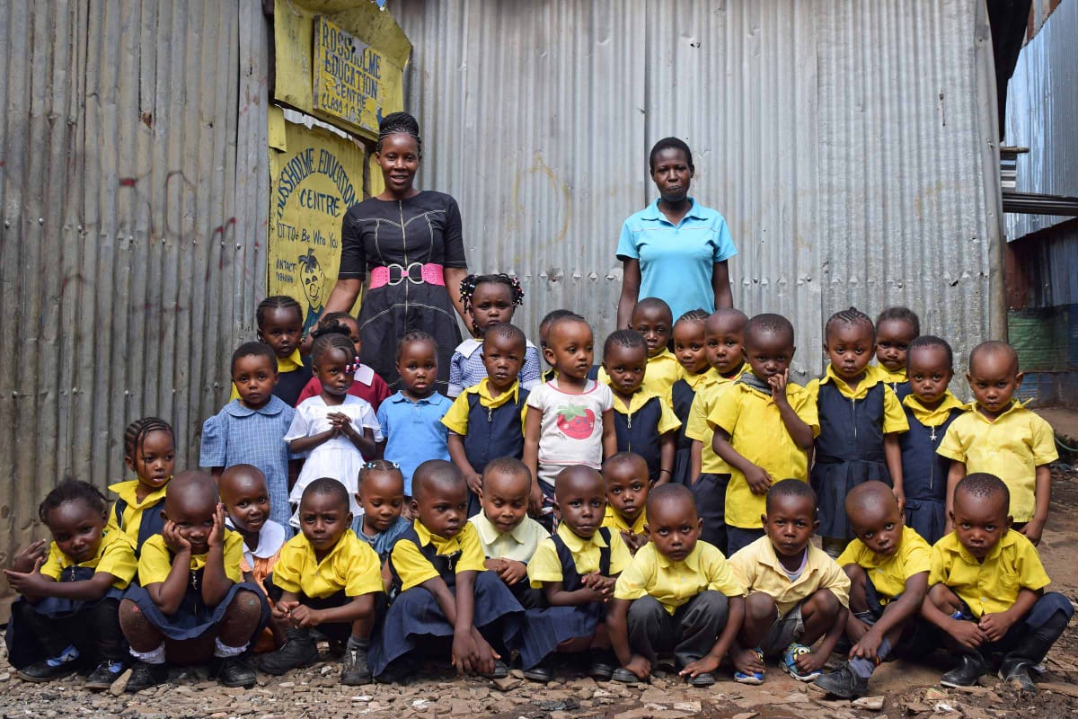 A group of children in school uniforms are posing for a picture.