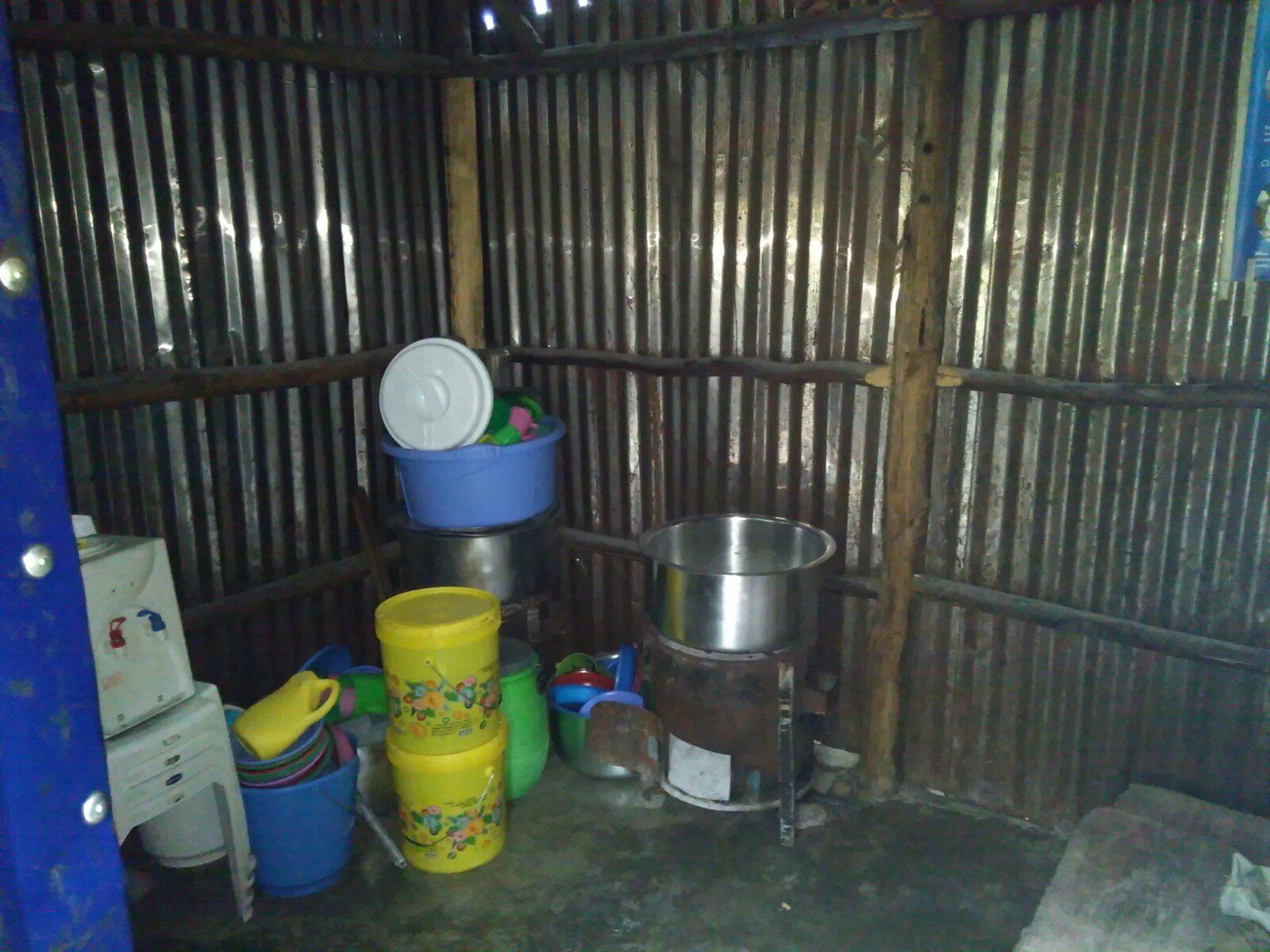 A room with a lot of buckets and pots on the floor