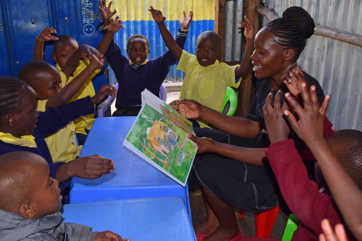 A woman is reading a book to a group of children