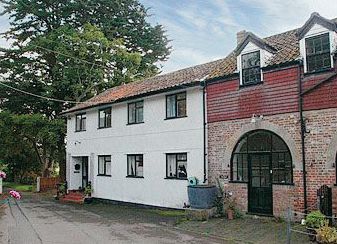 A large white house with a red brick building next to it.