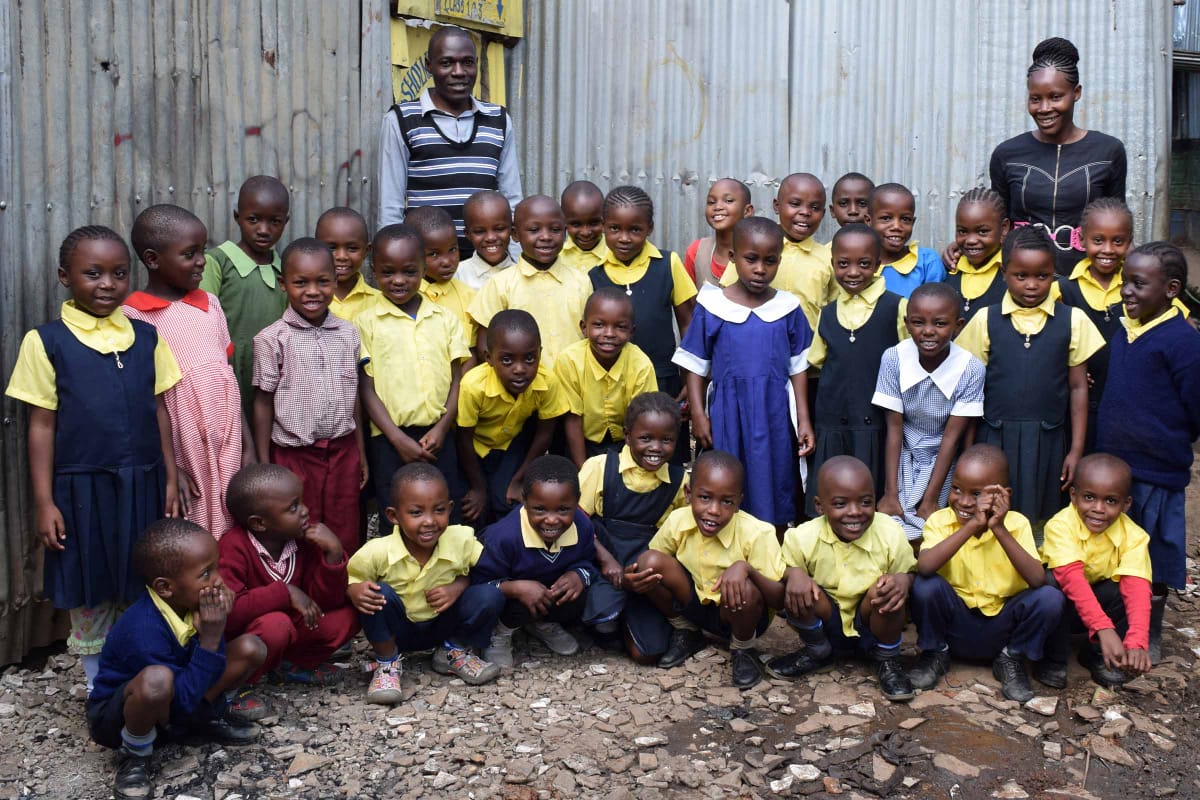 A group of children in school uniforms are posing for a picture.