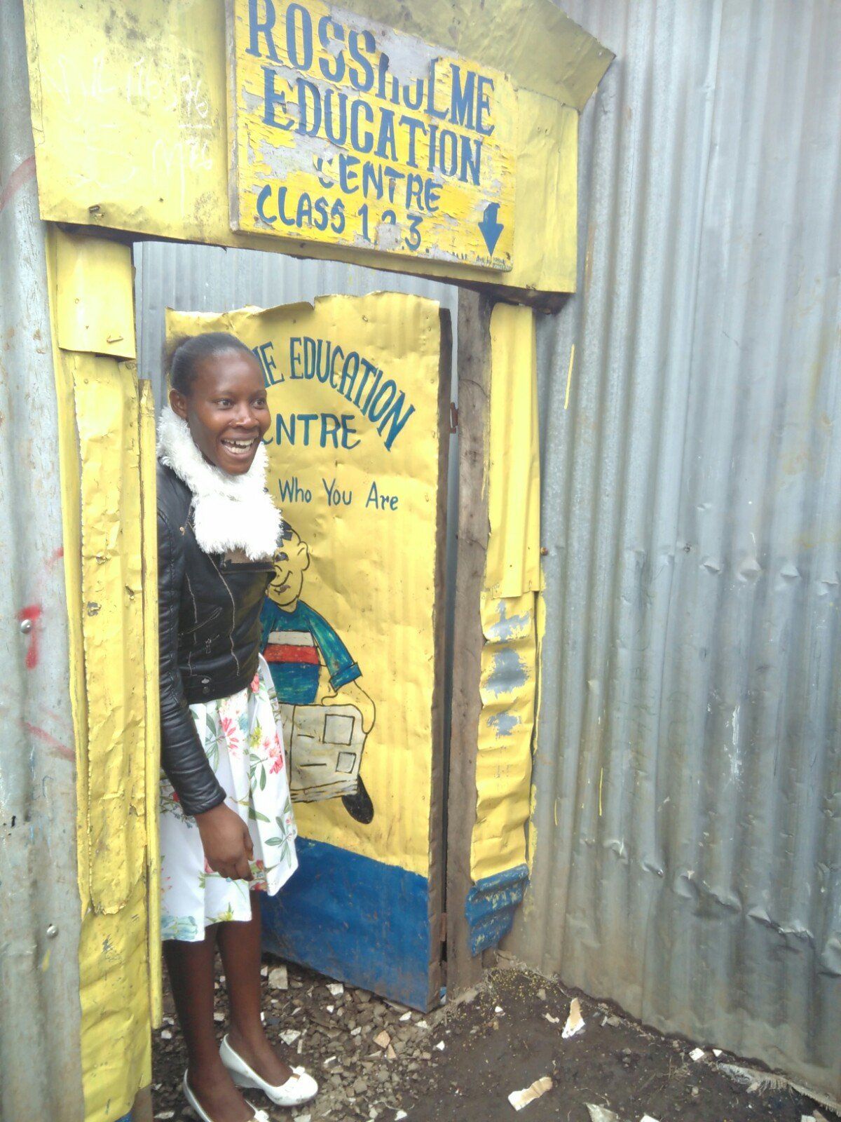 A woman stands in front of a door that says rossi and me education centre