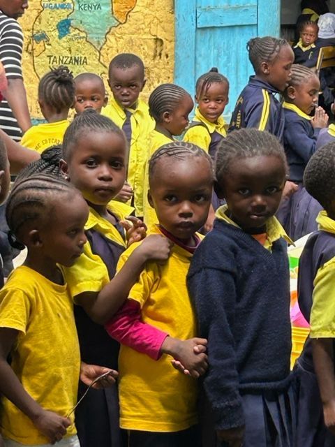 A group of children standing in front of a map of tanzania