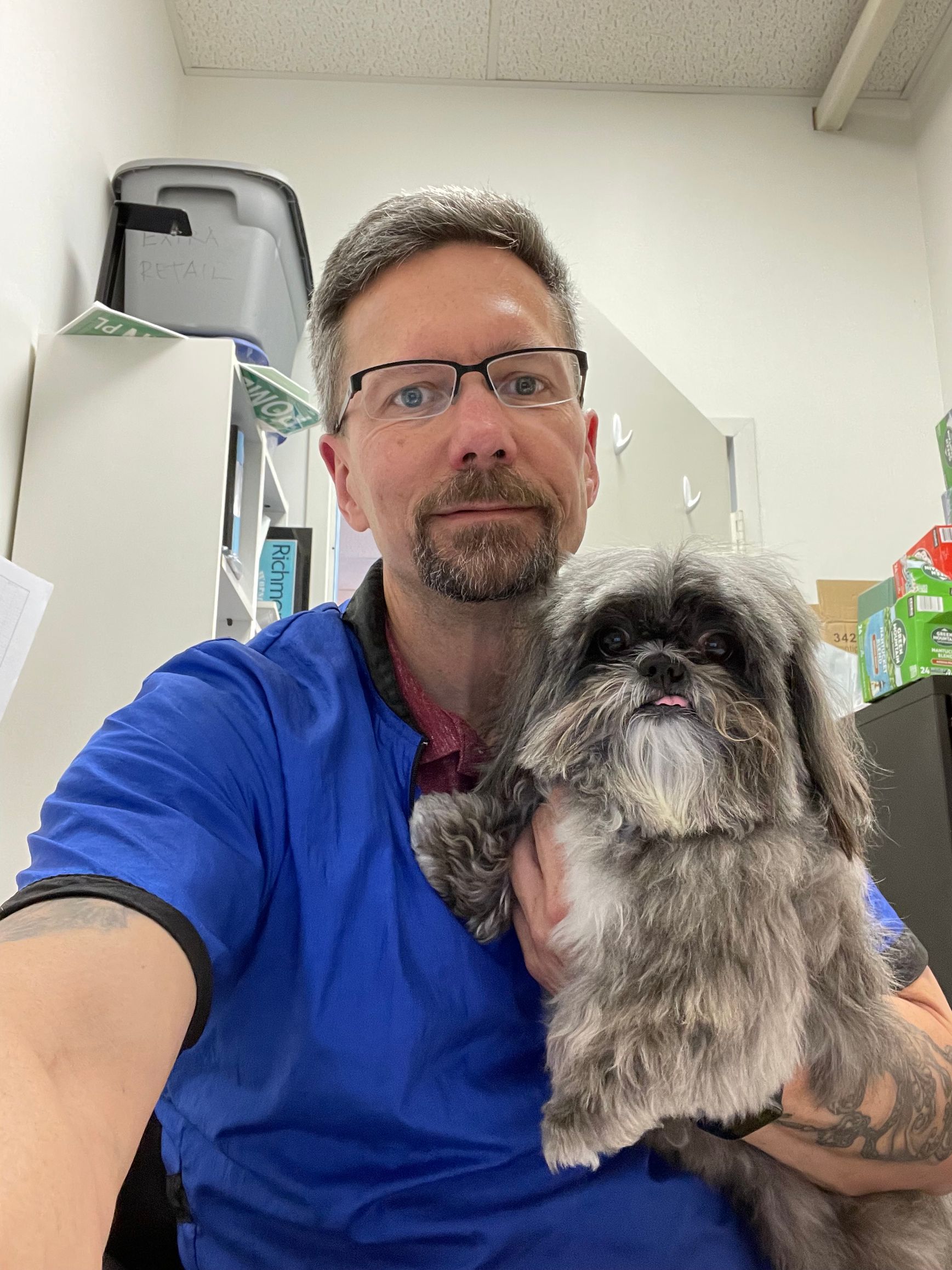 A man is holding a small dog in his arms.