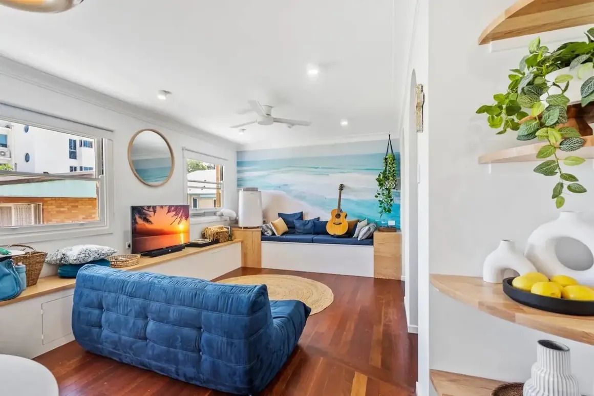 A Living Room With a Blue Couch , a Television , and a Guitar — Byron Bay Carpentry and Construction In Suffolk Park, NSW