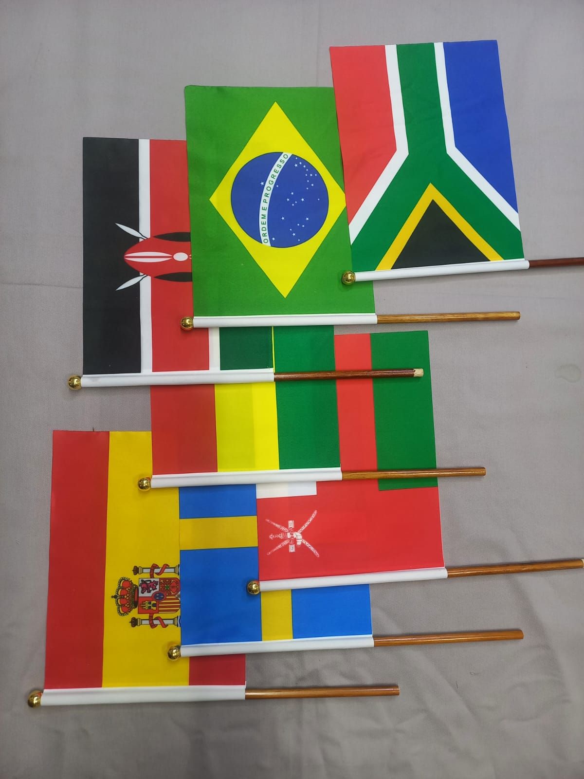 Diversas banderas nacionales en miniatura, colocadas sobre palos dispuestas superpuestas.