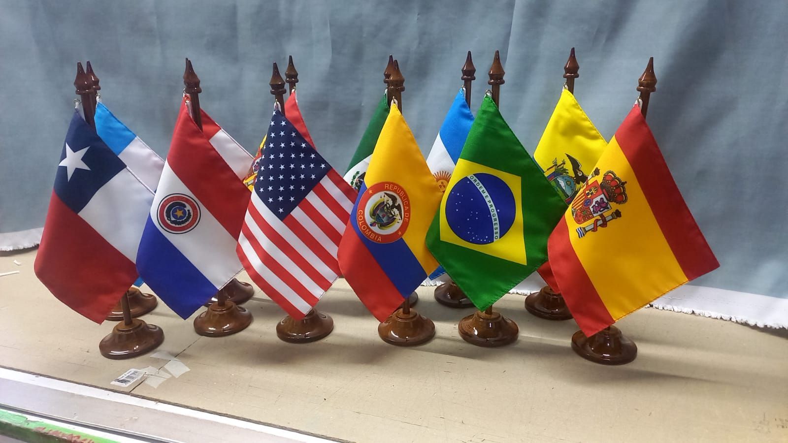 Seis pequeñas banderas de mesa de Chile, Panamá, Estados Unidos, Ecuador, Brasil y España sobre soportes.