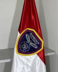 Bandera roja y blanca con un emblema triangular azul sobre un soporte en el interior.