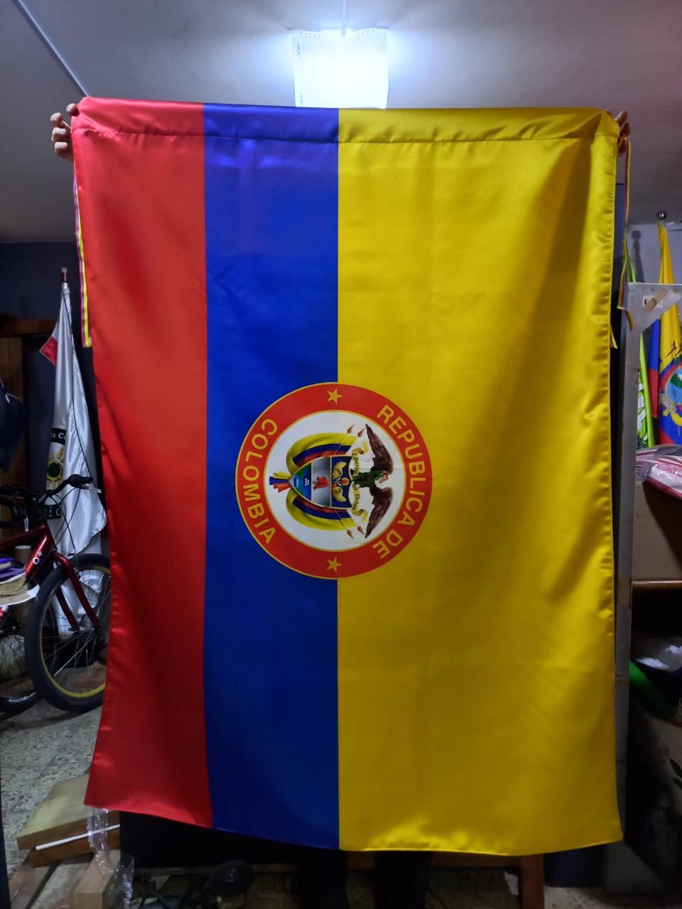 Bandera roja, azul y amarilla con un escudo circular colgada en el interior.