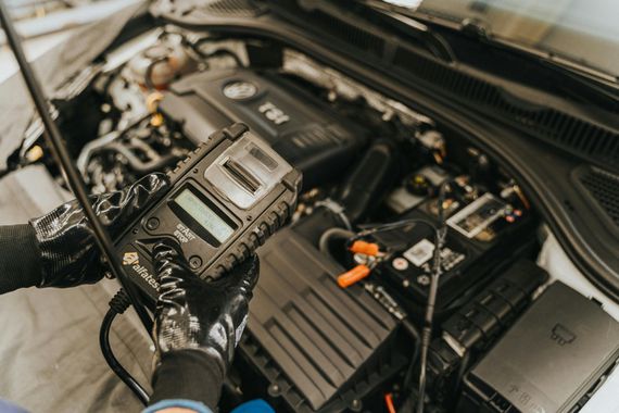 A person is working on the engine of a car.