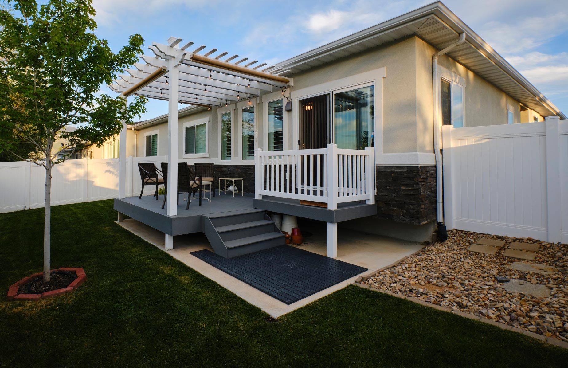A house with a deck and a pergola in the backyard