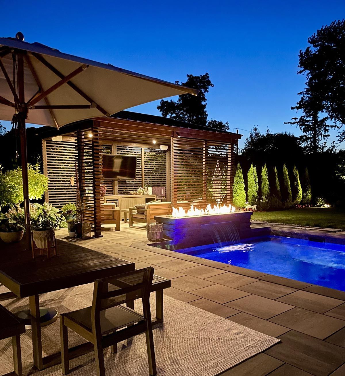 A large swimming pool with a fire pit in the middle