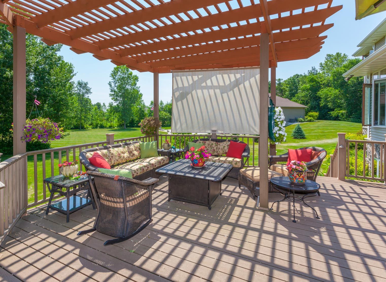 A patio with a pergola and a lot of furniture on it.