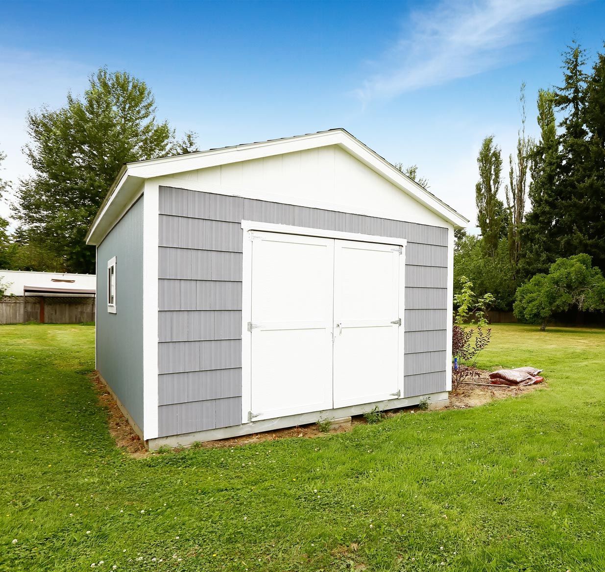 A small shed in the middle of a lush green field