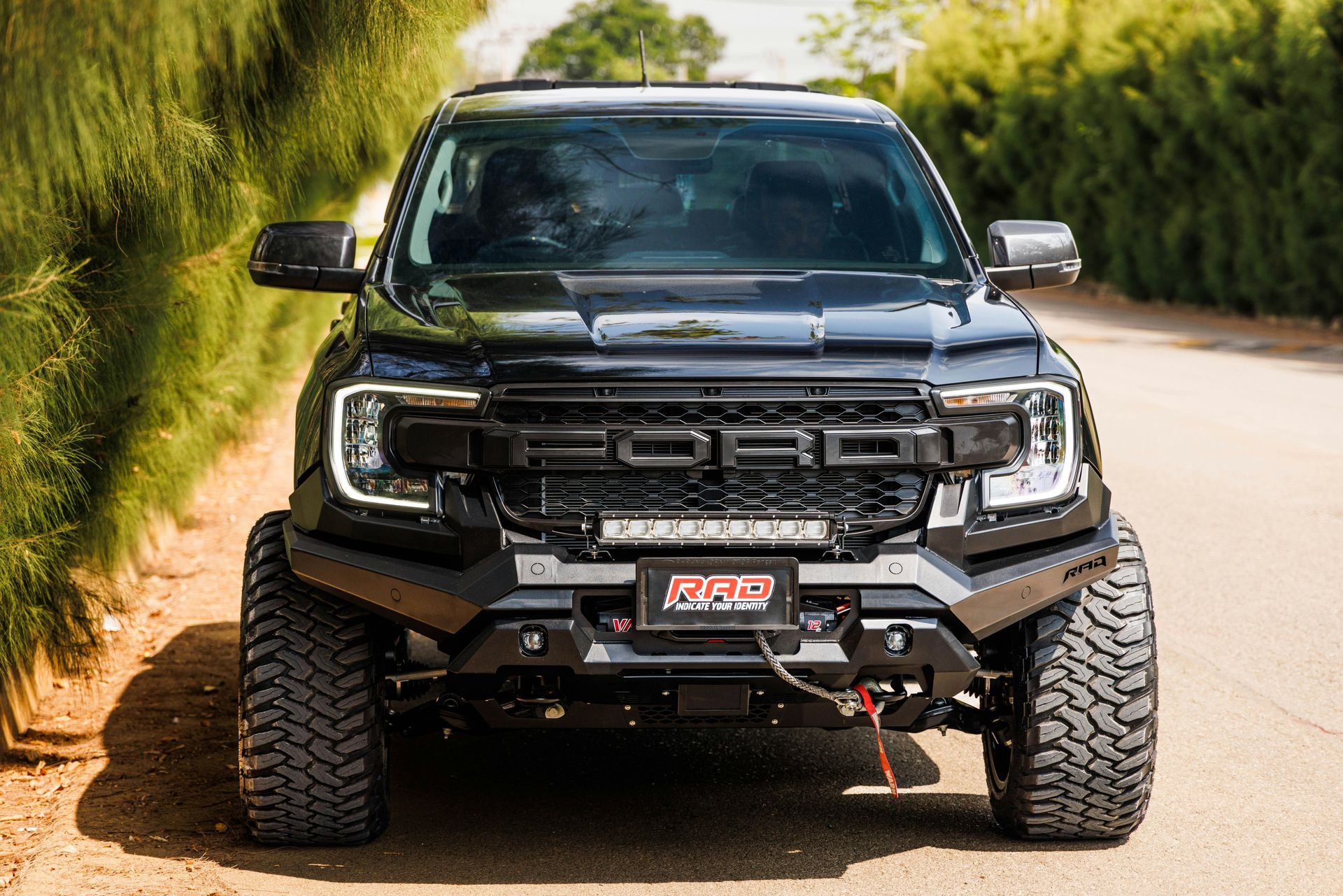 A black ford raptor is parked on the side of a dirt road. | Alaska Diesel Repair