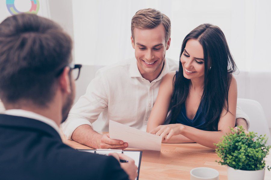 Agent and Couple Reviewing Documents — Health Insurance in Australia