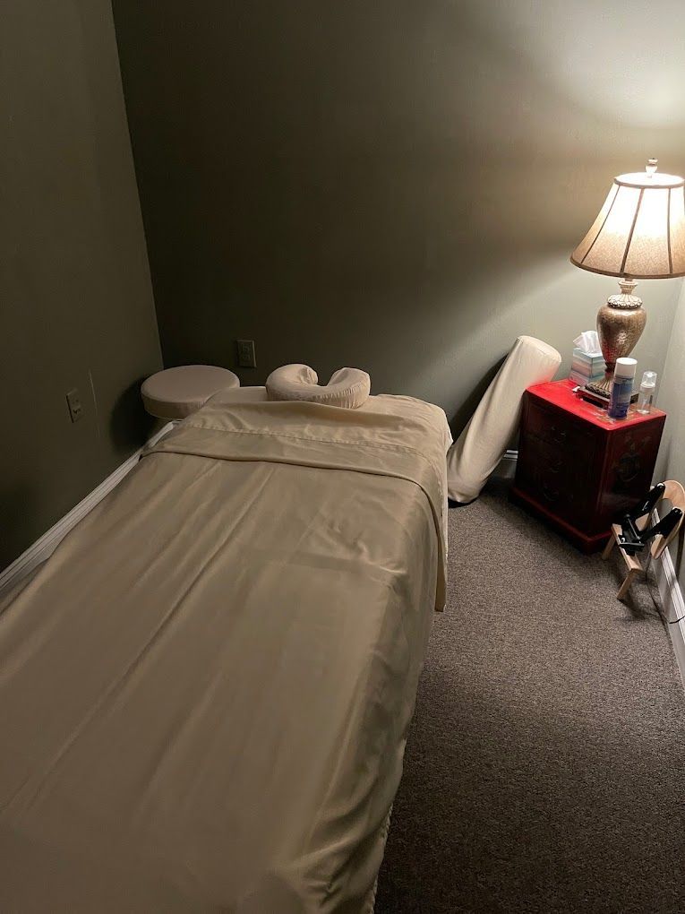 A Massage Table is Sitting in a Room Next to a Lamp
