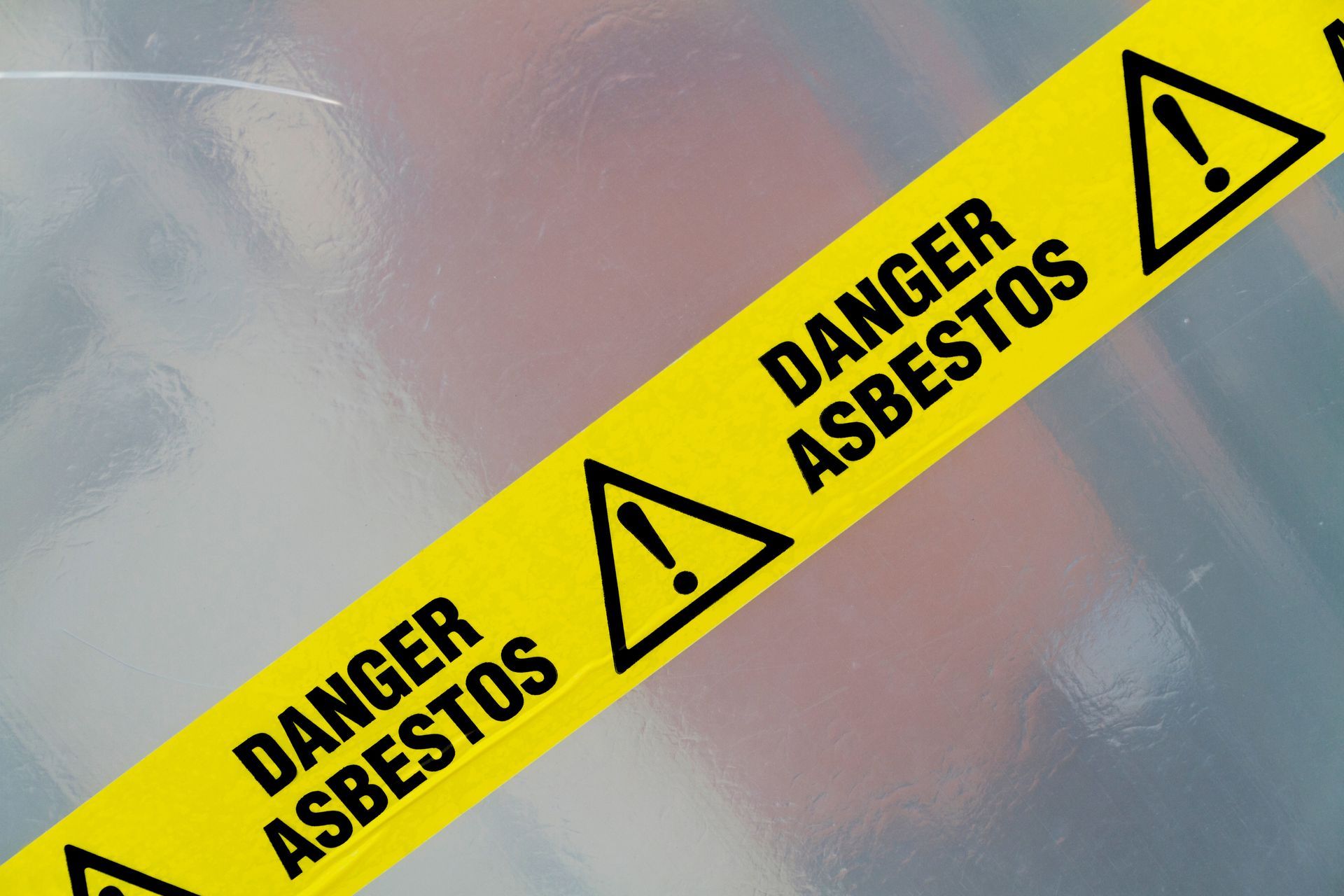 Yellow warning tape reading Danger Asbestos with hazard symbols. Yellow warning tape reading Danger Asbestos with hazard symbols.