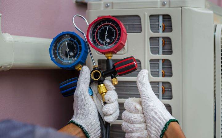 man giving thumbs up while holding manifold gauge
