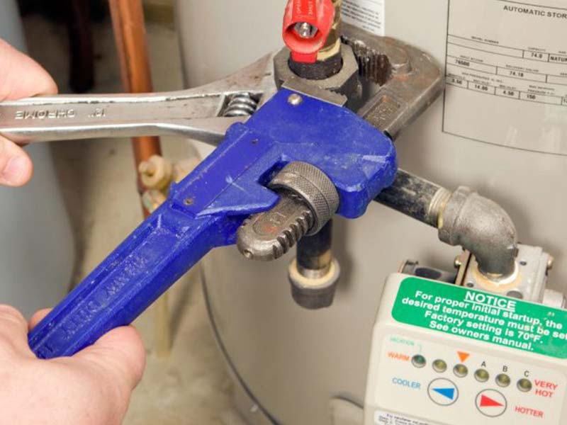 A plumber checking a hot water system in Kurri Kurri