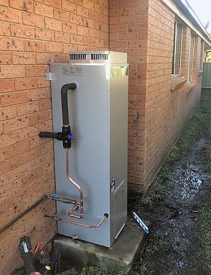 A hot water system installed on the exterior of a home in Kurri Kurri