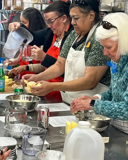 A group of women are preparing food in a kitchen.