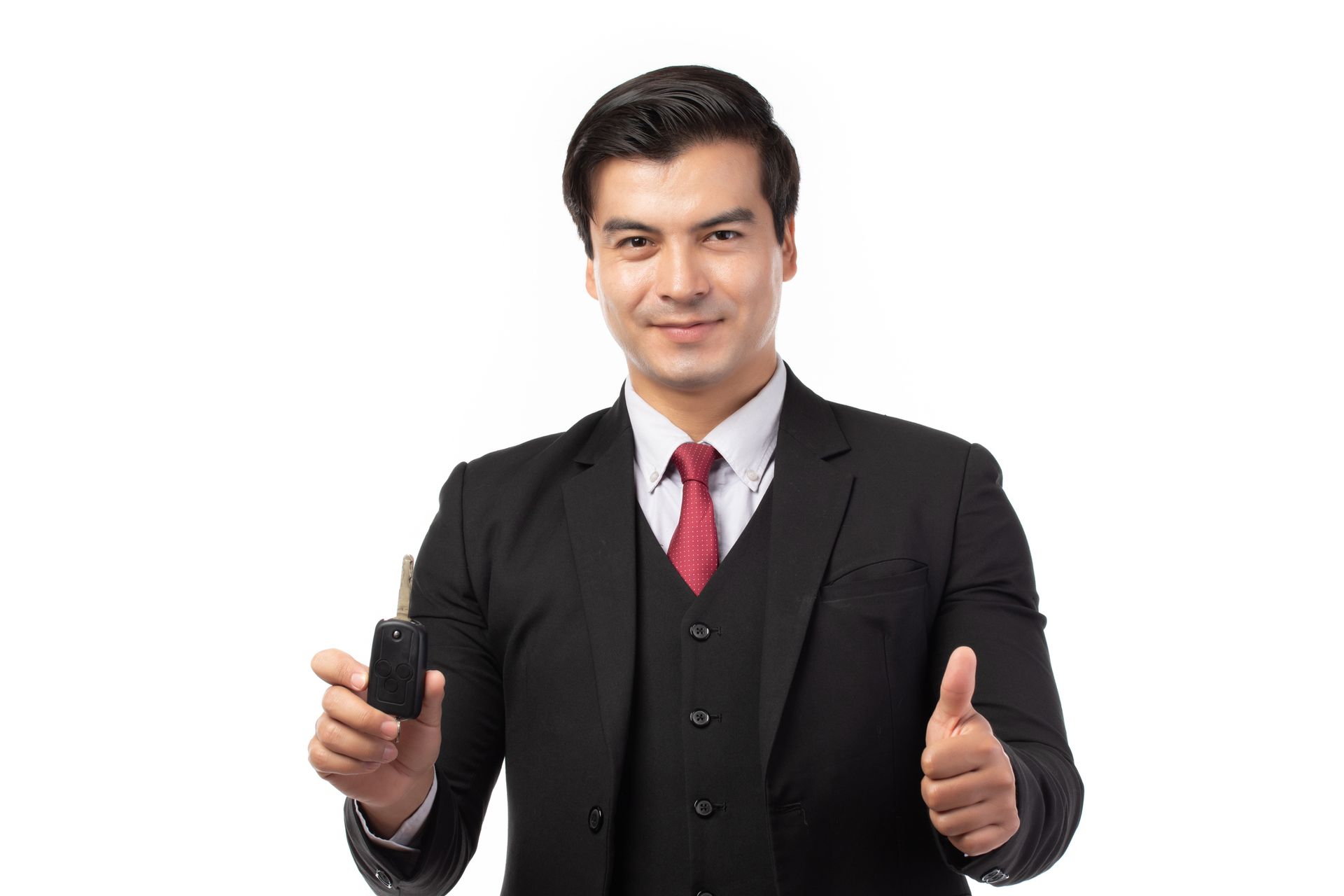 Man in suit holding car keys, giving thumbs up, smiling.