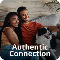 A smiling couple and a dog on a couch. The text