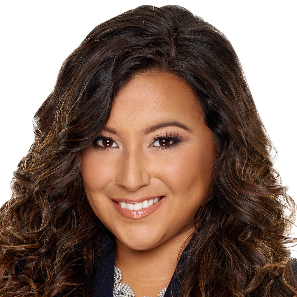 Woman with long brown curly hair smiles.