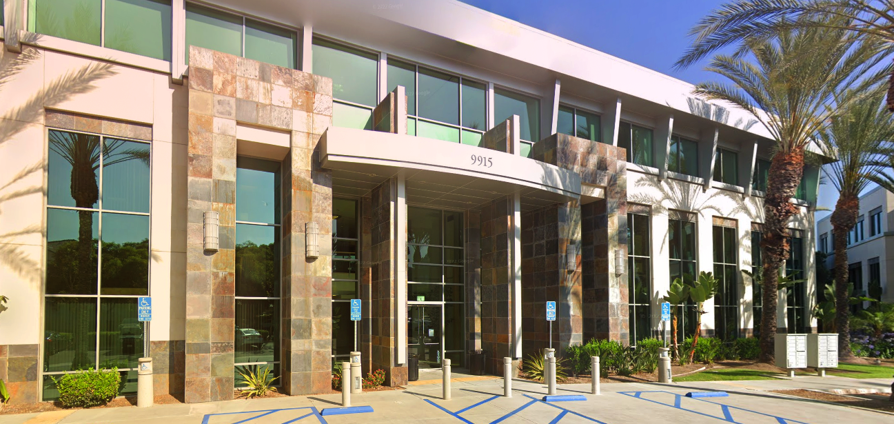 Exterior view of a modern two-story building with large windows and a stone facade.
